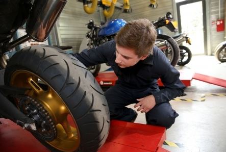 Man Inspects Motorcycle Tire