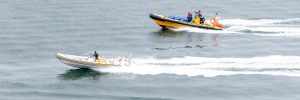 Three Marine Boats racing out on the waters