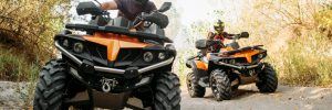 Two people riding four-wheelers
