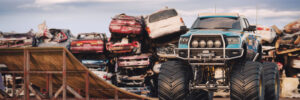 Monster Truck next to pile on of cars