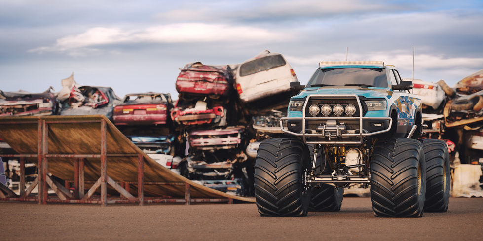 Monster Truck next to pile on of cars